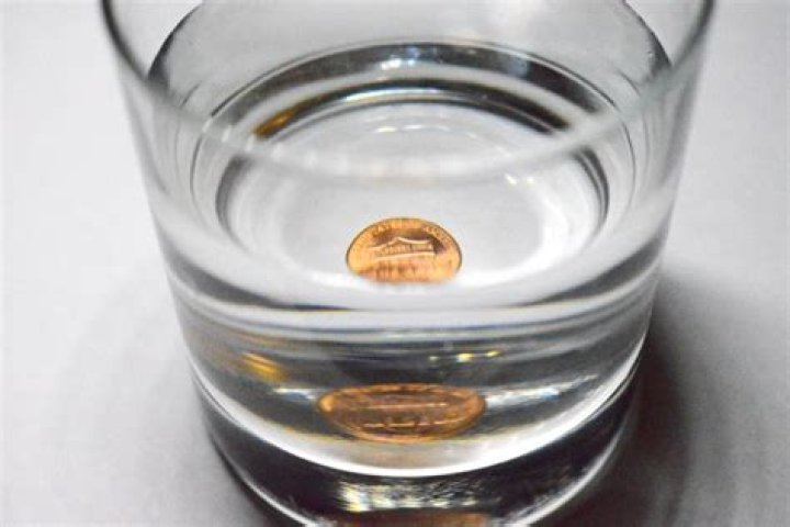 Why the coin disappears when water is added to the glass?